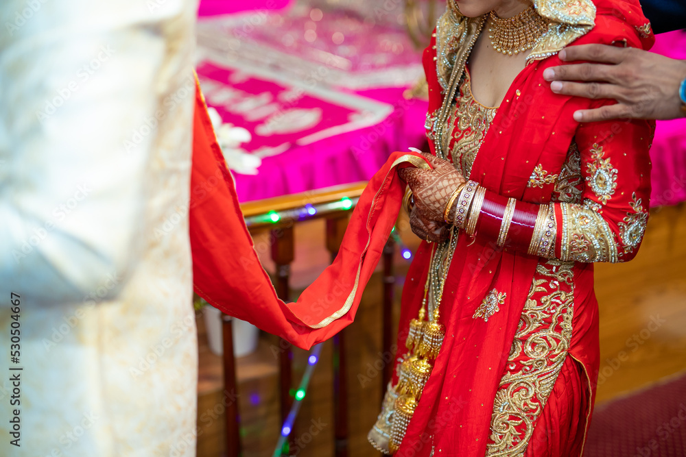 Indian Punjabi bride's red wedding outfit hands close up