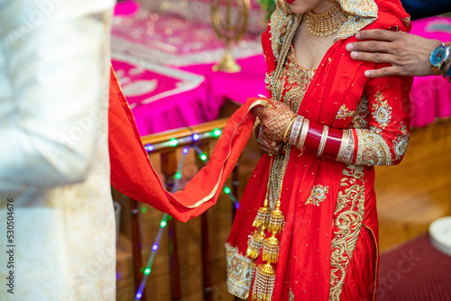 Indian Punjabi bride's red wedding outfit hands close up © Stella Kou