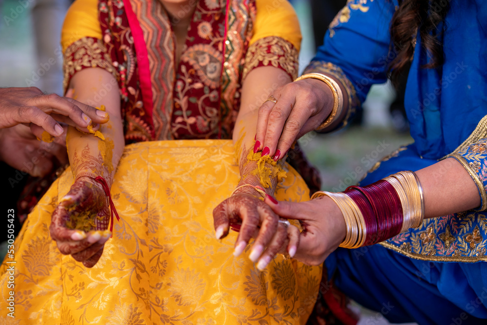 Indian Punjabi pre wedding Maiyan turmeric ceremony ritual items and hands close up