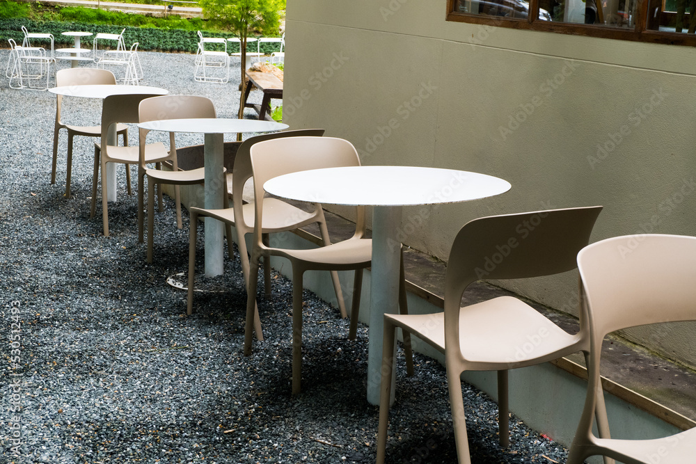 Modern white chairs and table in garden.