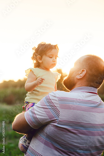 parent and child in the garden walking in golden hour