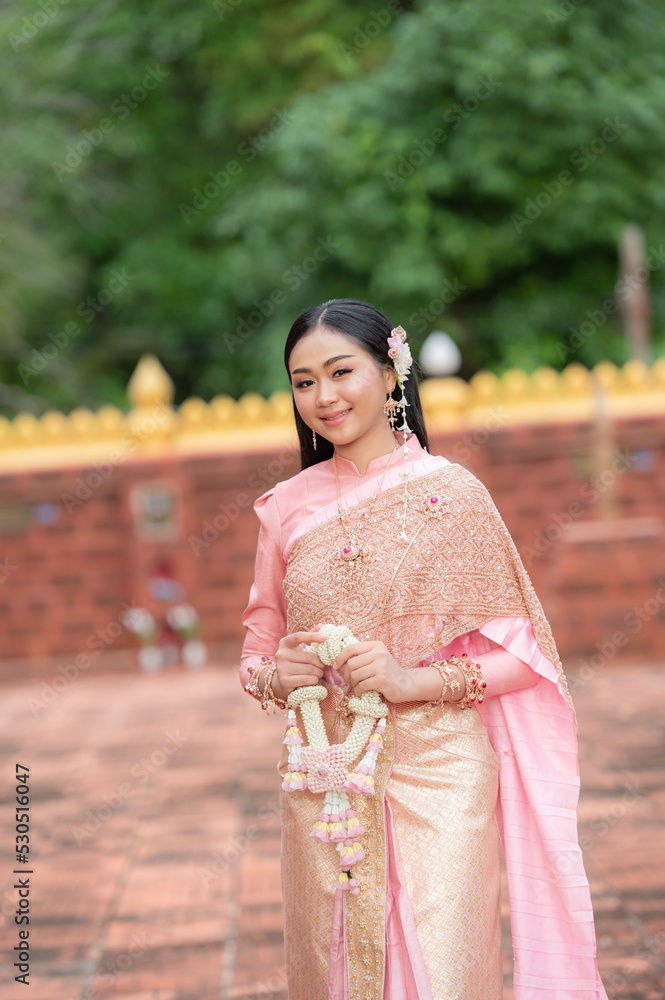 Fototapeta premium Beautiful asian woman with Thai traditional costume holding garland