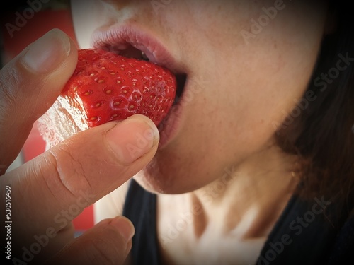 woman eating strawberry