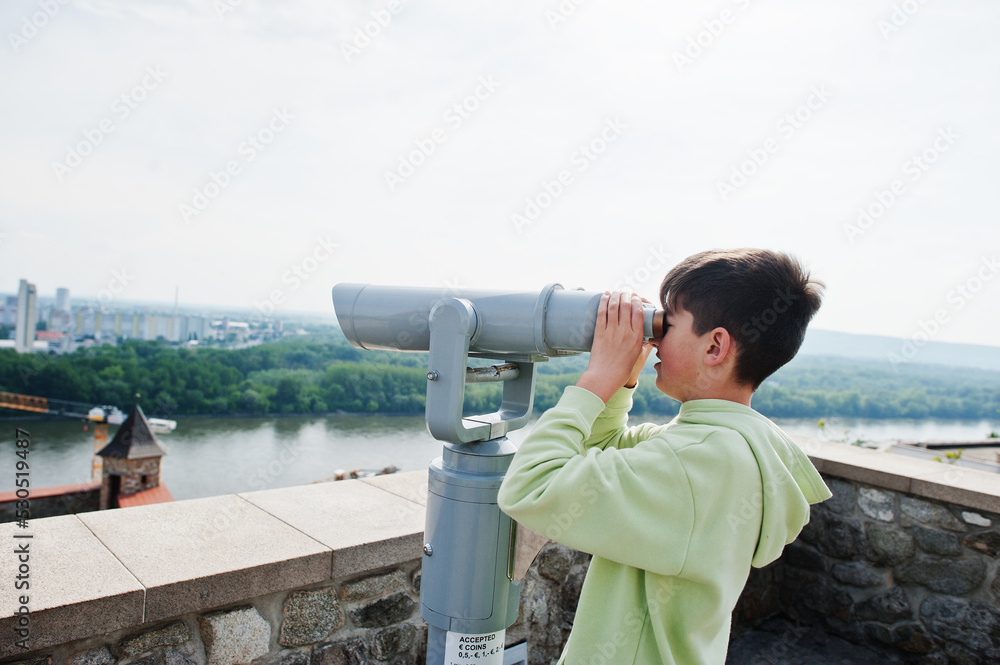 Obraz premium Boy looking at touristic telescope of Bratislava view, Slovakia.