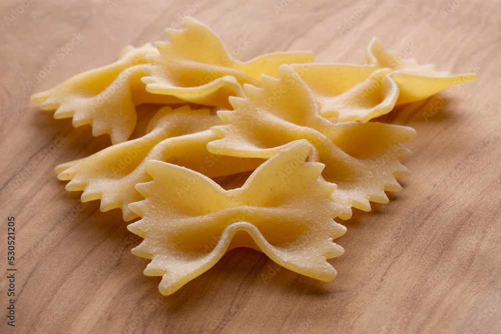 small compositions of durum wheat pasta with wooden background