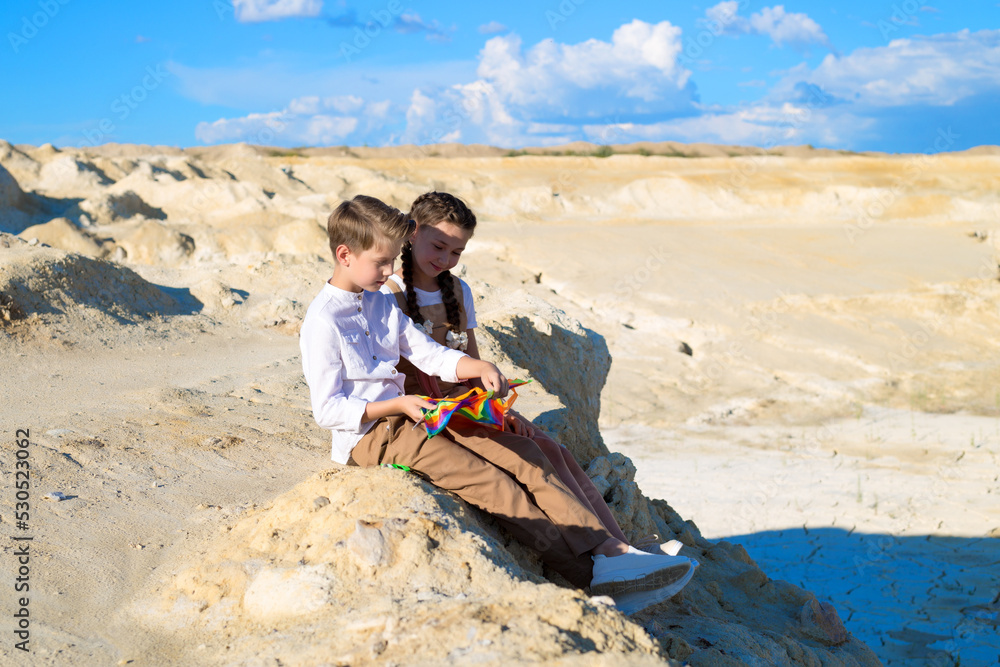 Brother and sister watching a kite sitting a mountain. Brother and sister watching a kite sitting a mountain.