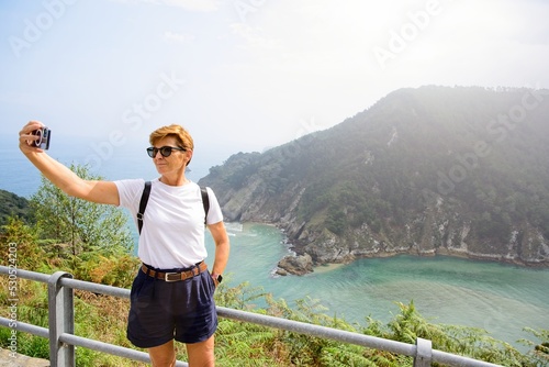 Woman taking a selfie in a viewpoint by the sea