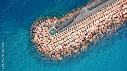 Tableau sur toile Aerial of the breakwater and a lighthouse on it in the sea.