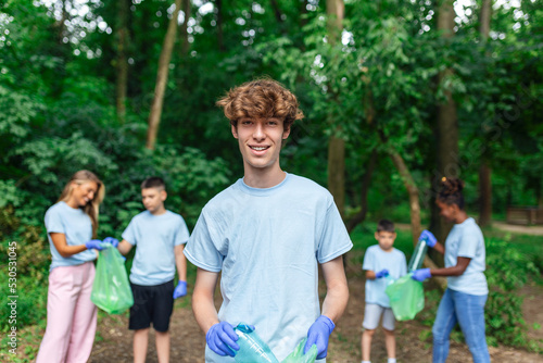 Young responsible people doing community charity work in the park. Group of people, cleaning together in public park, saving the environment. © Graphicroyalty