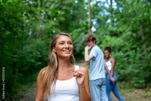 Disloyal man walking with his girlfriend and looking amazed at another seductive girl photo