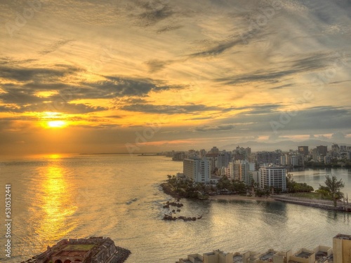 Aerial view of coastal San Juan cityscape during bright cloudy sunrise photo