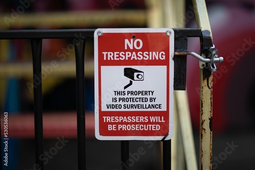 Closeup shot of a no trespassing warning red sign photo