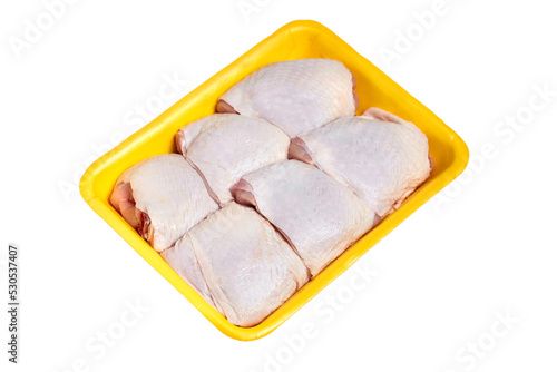 Raw chicken thighs in a yellow tray, isolated