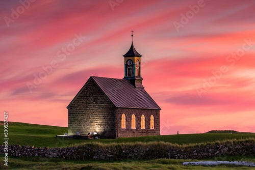 Hvalsneskirkja church against pink cloudy sunset sky background in Sandgerdi, Iceland photo