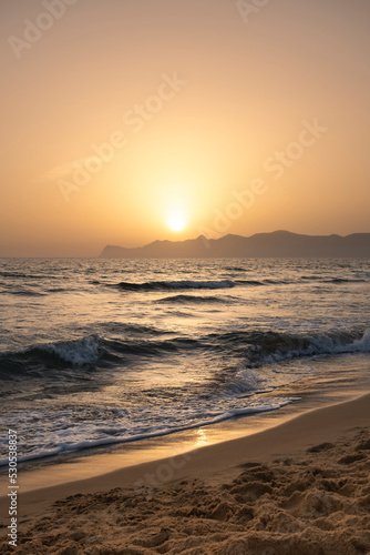 Sun sets behind the mountains in the background. Beautiful orange sunset. Relax  evening on vacation.