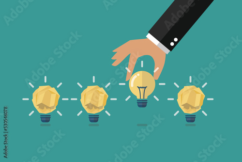 Hand picking up the perfect idea among the crumpled paper ideas
