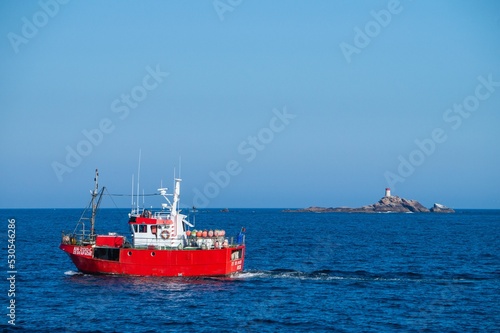 A red boat that constrast with blue sea photo