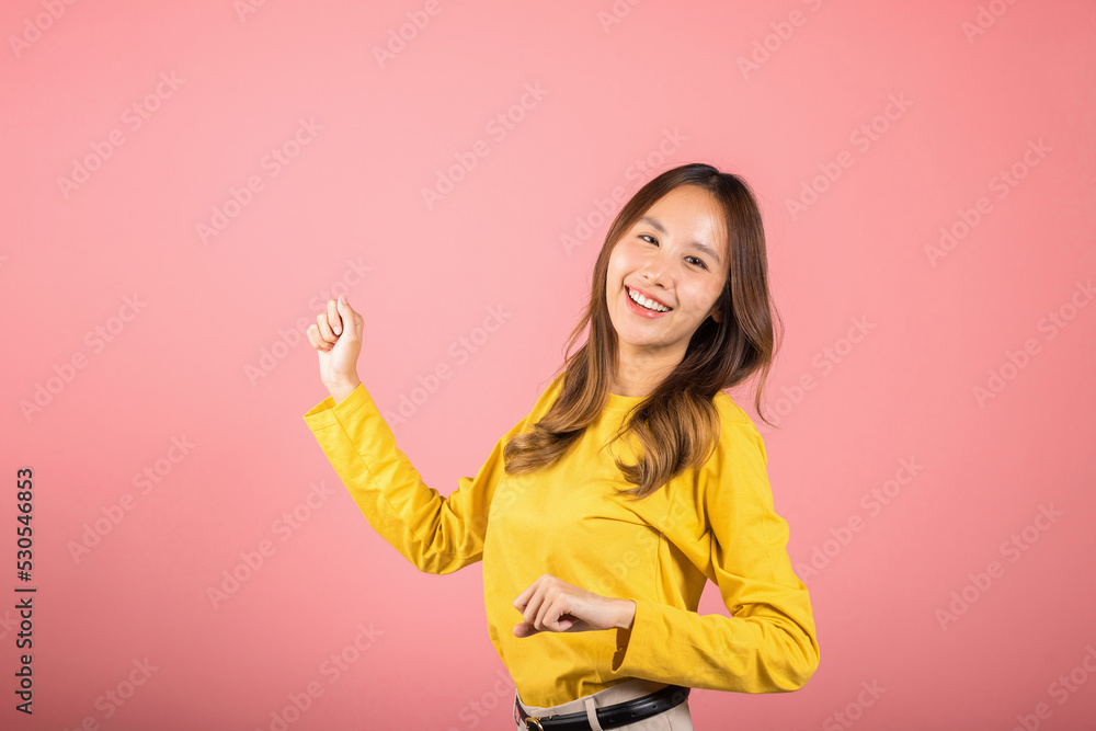 Asian young woman dancing with inspired face expression and raising hands up, Portrait of happy female model jocund in sneakers dancing, studio shot isolated on pink background, Time to relax Asian young woman dancing with inspired face expression and raising hands up, Portrait of happy female model jocund in sneakers dancing, studio shot isolated on pink background, Time to relax