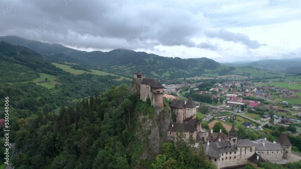 Drone flying towards Orava castle, Slovakia in middle of green landscape on cloudy day Drone flying towards Orava castle, Slovakia in middle of green landscape on cloudy day