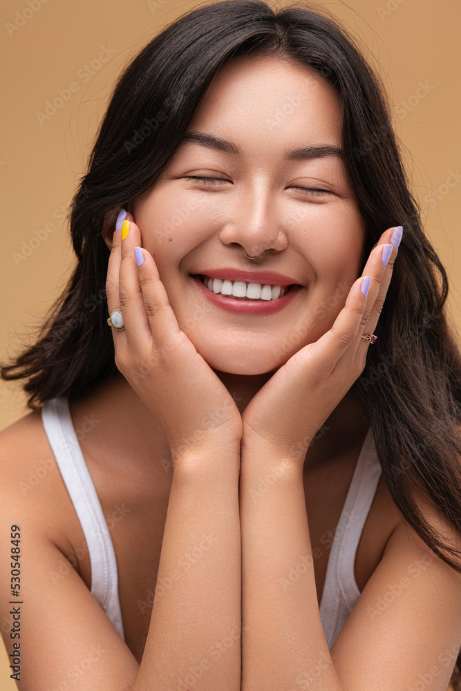 Happy Asian woman touching face Happy Asian woman touching face