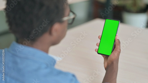 Young African Man Using Smartphone with Green Screen