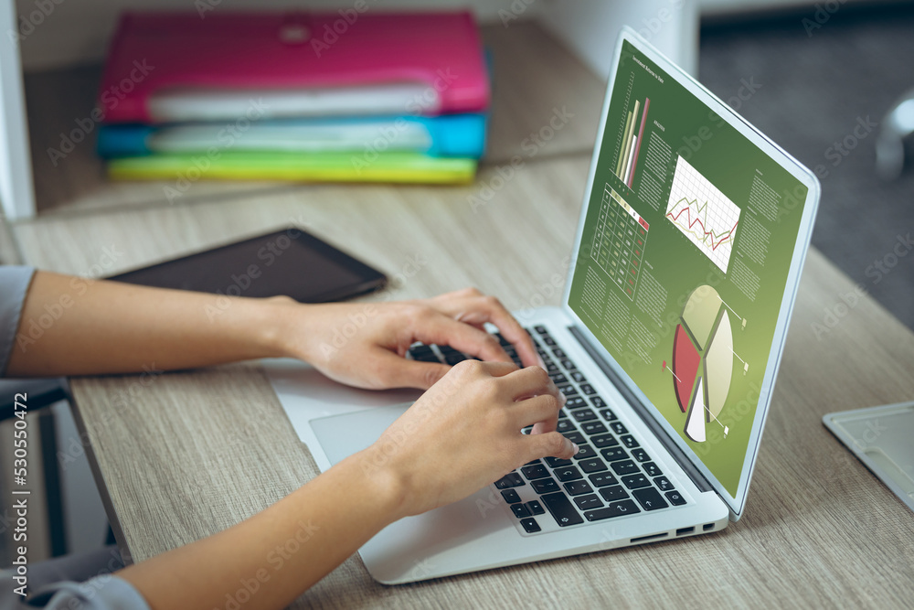 Hands of caucasian businesswoman at desk using laptop with charts and data on screen Hands of caucasian businesswoman at desk using laptop with charts and data on screen