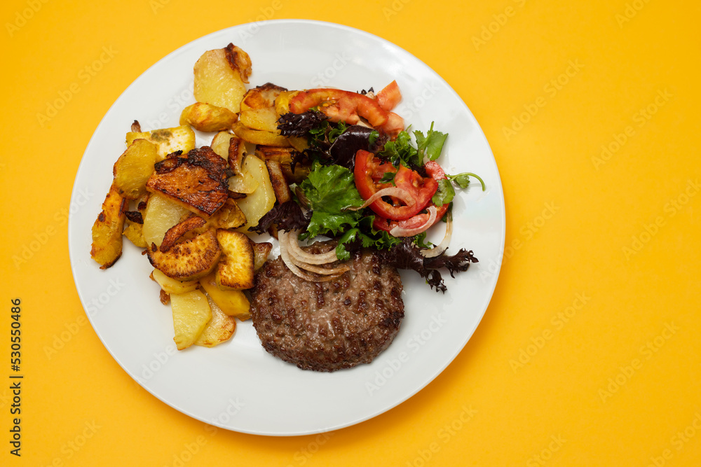 three fried ground meat with fried potato and fresh salad on the plate