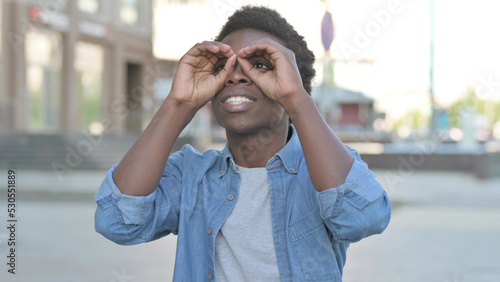 Outdoor Young African Man Searching with Handmade Binocular © stockbakers