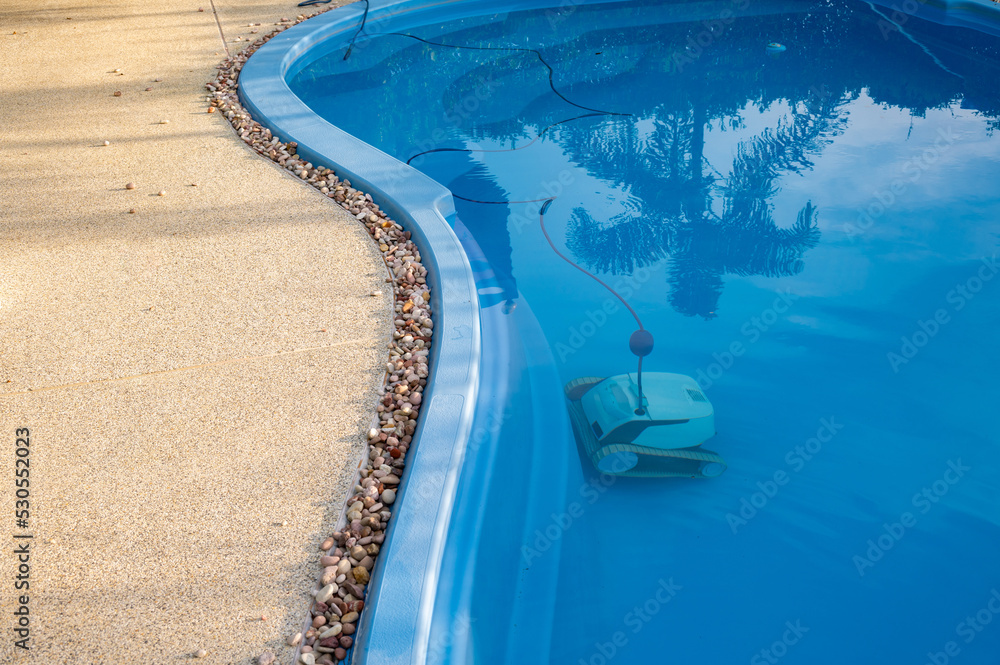 Fototapeta premium Robotic pool cleaner during on duty. Robotic is solutions for swimming pool care, deep clean pool surfaces, removing leaves for you.