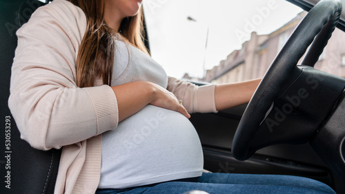 Pregnant driving car. Young smiling pregnancy woman driving car. Safety pregnant young mom driving concept. © Maksym