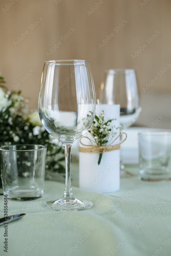 in a bright room, with daylight, a festive table is decorated, with plates and glasses in a bright room, with daylight, a festive table is decorated, with plates and glasses