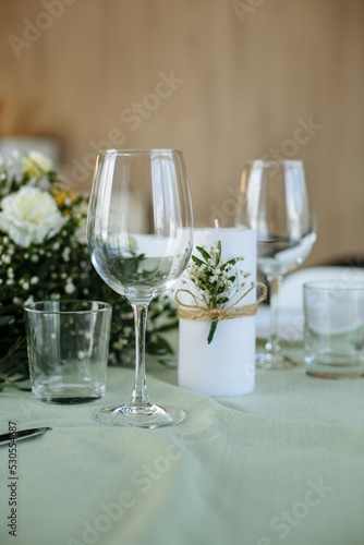 in a bright room, with daylight, a festive table is decorated, with plates and glasses
