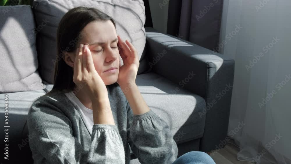 Nervous breakdown, crisis concept. Tired frustrated brunette girl touching head, feeling headache, migraine, sitting on grey couch at home. Depressed young woman coping with loss, grief, trauma Nervous breakdown, crisis concept. Tired frustrated brunette girl touching head, feeling headache, migraine, sitting on grey couch at home. Depressed young woman coping with loss, grief, trauma
