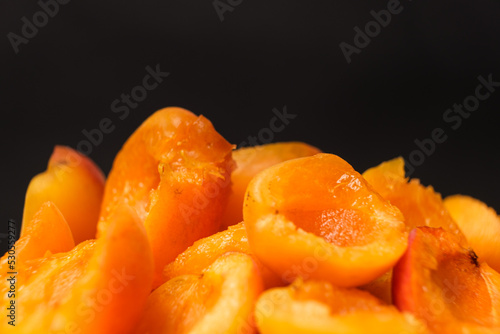 Juicy apricot slices on a black background, side view, space for text.