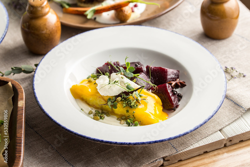 Healthy meal with grilled chicken, beets and cheese on white plate on the table