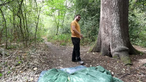 Cool man with sunglasses gets angry when fails to assemble tent in forest