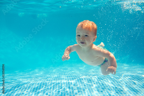 Baby Boy With Family On Summer Holiday Swimming Underwater In Pool