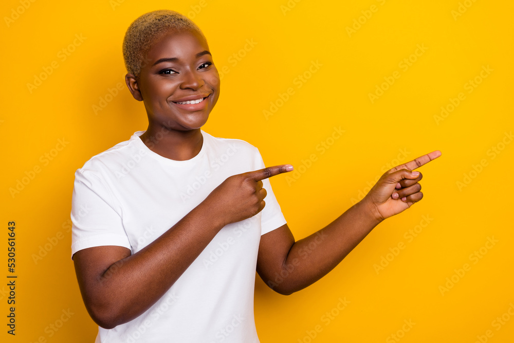 Profile side photo of positive girl two arm finger point index promo sale trendy clothes empty space isolated on yellow color background