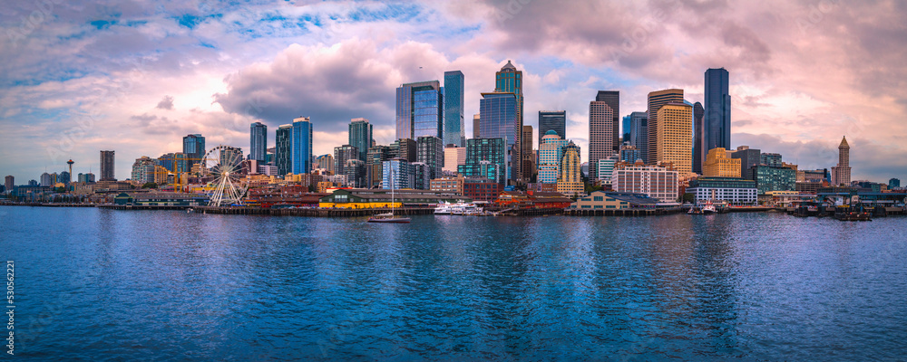 Seattle city skyline at sunset, dramatic cloudscape, and the vista of the metropolitan downtown financial district over Elliot Bay in Washington State - obrazy, fototapety, plakaty 