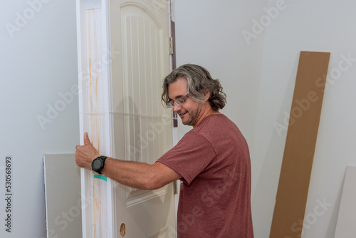 Worker holds the door in preparation for installation in a new house