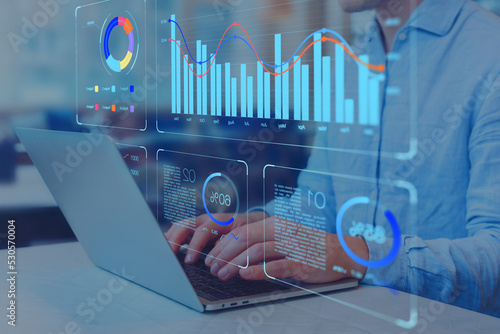 Analyst working on business analytics dashboard with KPI, charts and metrics to analyze data and create insight reports for executives and strategical decisions. Operations and performance management. photo