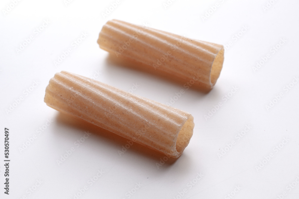 small composition of whole durum wheat pasta on a white background small composition of whole durum wheat pasta on a white background