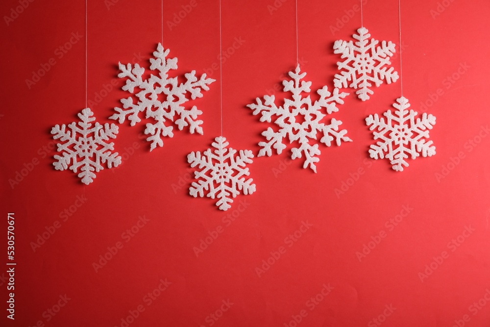 Beautiful decorative snowflakes hanging on red background Beautiful decorative snowflakes hanging on red background