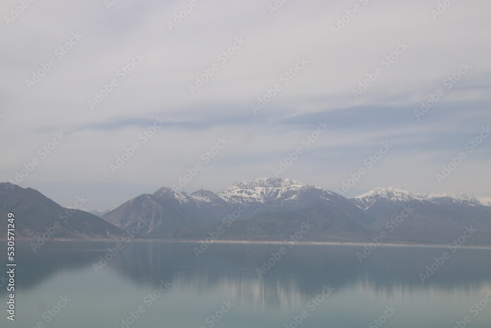 Beautiful lake mirroring the icy mountain peaks above in cloudy weather