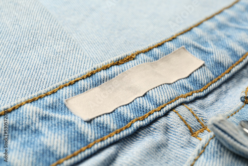 Blank clothing label on light blue jeans, closeup