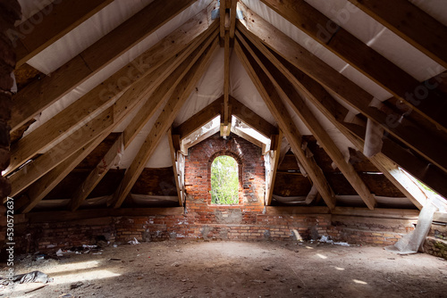 Old ruined attic with red bricks and wooden planks