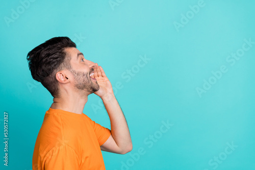 Side profile photo of young handsome attractive man speak talk rumor new information funny face look empty space isolated on cyan color background