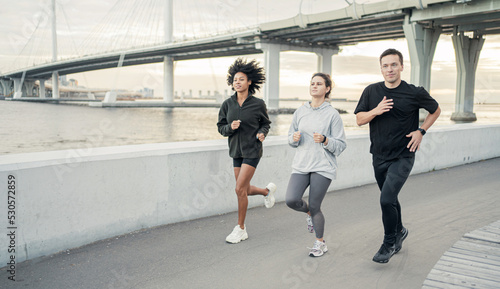 A group of people are runners in sportswear. Friends workout fitness running in the city.