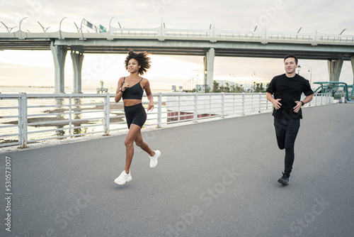 A group of men and women fitness on the street. People friends athletes run for health and happiness.