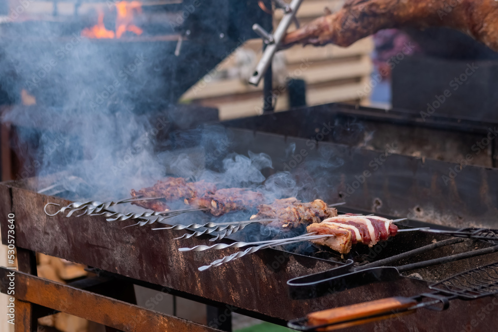 Process of grilling skewers of pork meat and lard at summer local food market - close up view. Outdoor cooking, barbecue, kebab, gastronomy, cookery and street food concept Process of grilling skewers of pork meat and lard at summer local food market - close up view. Outdoor cooking, barbecue, kebab, gastronomy, cookery and street food concept